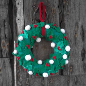 Knitting pattern for knitted Christmas wreath with holly leaves, snowballs and berries.