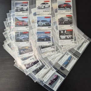 Peut inclure: Une collection de cartes de collection de voitures dans des pochettes en plastique transparent. Les cartes présentent divers modèles de voitures avec le mot "TURBO" en haut. Les cartes sont disposées en éventail, présentant la variété des véhicules.