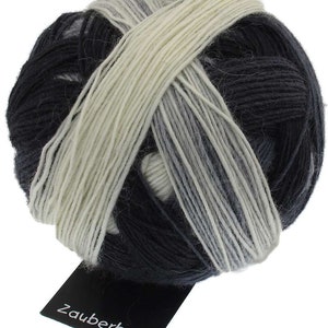 May include: A ball of yarn with a black, white, and gray color gradient. The yarn is wrapped around itself and has a label that says "Zauberball".