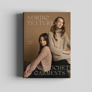 Puede incluir: Un libro de tapa dura titulado Nordic Textures in Crochet Garments de Linda Skuja. La portada muestra a dos personas con suéteres de ganchillo beige sobre un fondo marrón, con el título en letras serif blancas y crema.