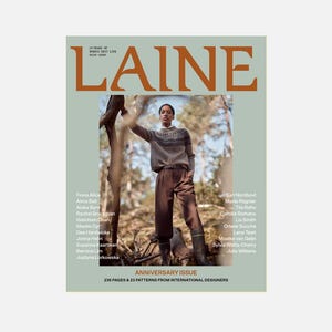 Può includere: La copertina del numero dell'anniversario della rivista Laine presenta uno sfondo verde chiaro con un grande testo arancione. Mostra una persona che indossa un maglione lavorato a maglia con motivi e pantaloni marroni, con un elenco di nomi e il testo 236 PAGES & 23 PATTERNS.