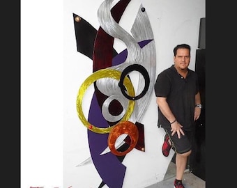 May include: Abstract metal wall art in various shapes and colours. The artwork features a silver, yellow, black, purple, and red design. The text "Viscardi Designs.com" and "Tony Viscardi" are visible.
