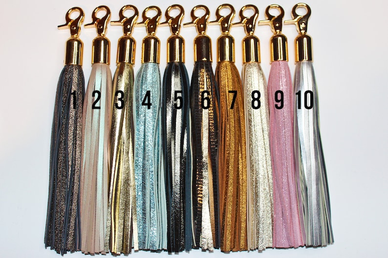 Pu&ograve; includere: Dieci portachiavi a nappa di diversi colori con chiusure dorate. Le nappe sono in pelle e hanno un effetto metallizzato. Le nappe sono numerate da 1 a 10.
