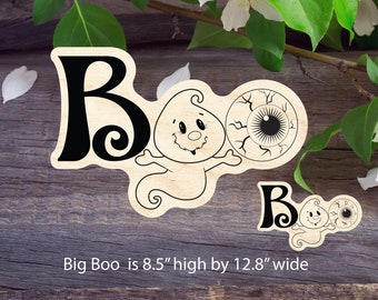 May include: Wooden Halloween sign with the word "Boo" in black lettering. The sign features a cartoon ghost with a big eye and a smaller ghost with a smaller eye. The sign is 8.5 inches high by 12.8 inches wide.