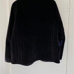 May include: A black quilted jacket with a stand-up collar.