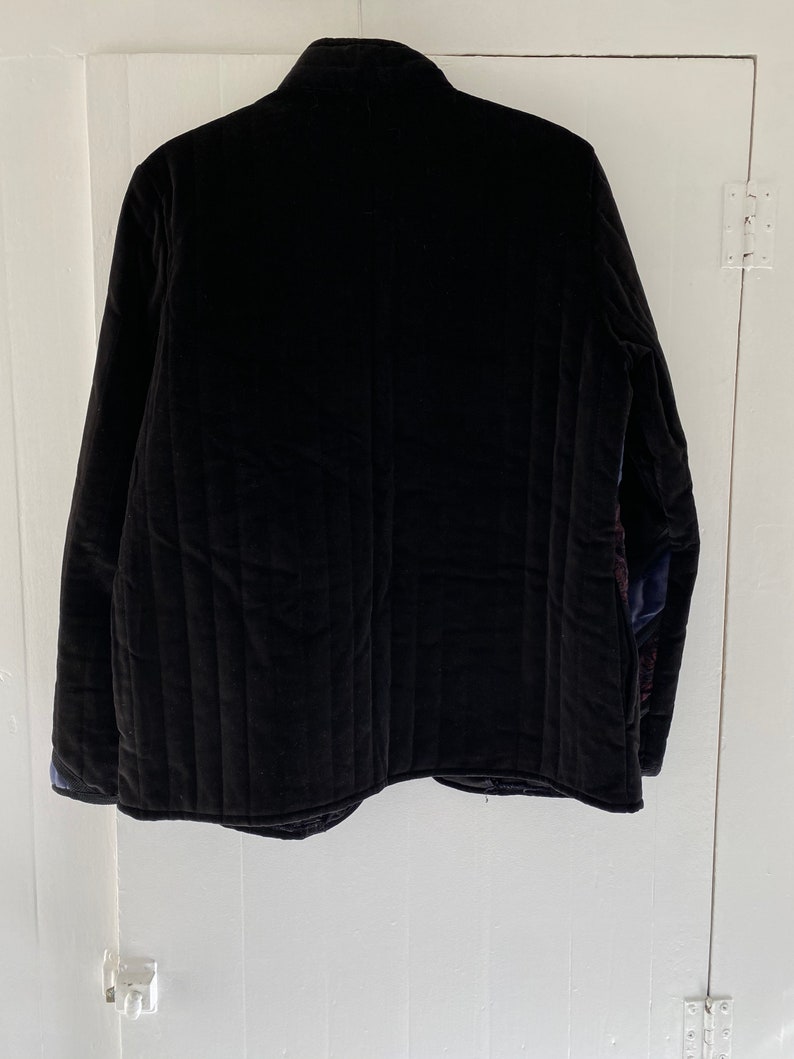 May include: A black quilted jacket with a stand-up collar.