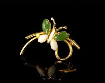 May include: A gold butterfly brooch with green jade wings and white pearl accents.