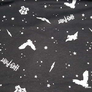 May include: Black fabric with a white repeating pattern of stars, lightning bolts, Harry Potter text, and flying birds.