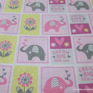 May include: Pink and gray fabric with a repeating pattern of elephants, flowers, hearts, and the text "Dream Big Little One".
