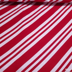 May include: Red and white striped fabric with diagonal stripes. The fabric is a cotton blend and is perfect for crafting projects.