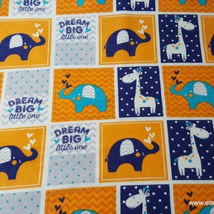 May include: A fabric with a repeating pattern of blue, orange, and white. The pattern features a giraffe, an elephant, and the text "Dream Big Little One".