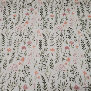 May include: A white fabric with a repeating pattern of small pink and orange flowers and green leaves.