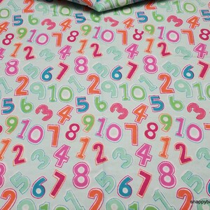 May include: A light blue fabric with a repeating pattern of colorful numbers from 1 to 10. The numbers are outlined in black and have a white interior.