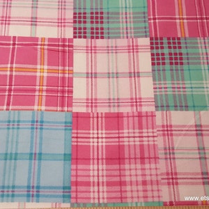 May include: A patchwork fabric with a plaid pattern in shades of pink, blue, and green. The fabric is divided into squares, each with a different plaid design. The overall effect is a colorful and cheerful design.