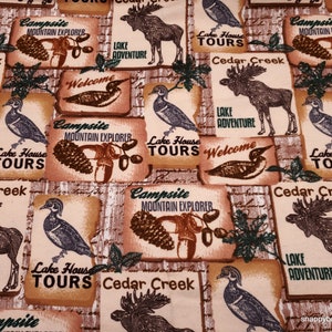 May include: A beige fabric with a repeating pattern of moose, ducks, pine cones, and leaves. The fabric features the text "Campsite Mountain Explorer", "Lake House Tours", "Cedar Creek", and "Lake Adventure".