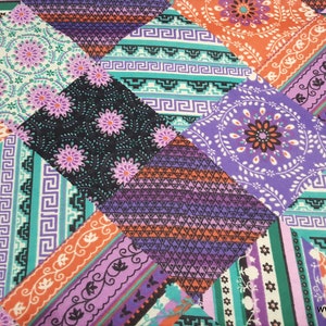 May include: A patchwork fabric with a variety of colorful patterns, including orange, purple, green, and black. The fabric features geometric designs, floral motifs, and paisley patterns.