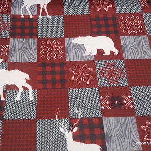 May include: A fabric featuring a patchwork design of red and black buffalo plaid, gray wood grain, and knit-look patterns. White silhouettes of deer, moose, and bears are interspersed with white snowflake motifs across the repeating square grid.