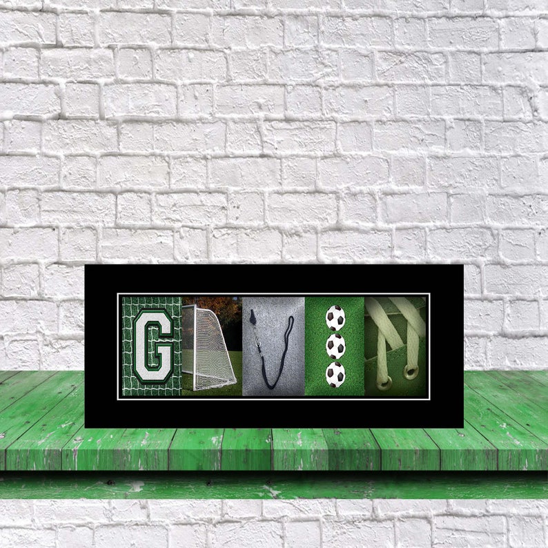 Op de afbeelding: Een ingelijste zwart-witfoto van de naam "GAVIN" gespeld met behulp van afbeeldingen die verband houden met voetbal. De letter "G" is een voetbaldoel, de letter "A" is een voetbal, de letter "V" is een voetbalschoen en de letter "N" is een voetbal.