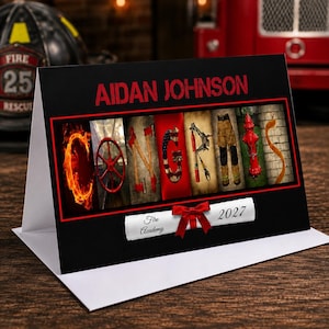 May include: A black greeting card featuring the name AIDAN JOHNSON in red text above a collage spelling CONGRATS using images of fire-related gear. Below, a white scroll graphic with a red bow displays the text Fire Academy 2027.