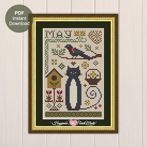 May include: A cross-stitch pattern featuring the text MAY, a black cat with a white chest, a bird on a branch, a birdhouse, a basket of flowers, and floral motifs in shades of green, yellow, red, and brown, presented as a digital PDF download.