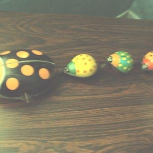 Antique metal toy in the shape of a ladybug that rolls and winds up with a key. It dates from the 1930s.