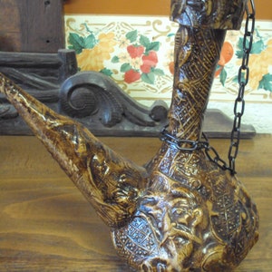 Carafe de style espagnol avec habillage cartonné représentant des visages.