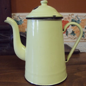 Yellow enameled metal coffee pot dating from the 1950s.