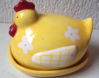 Beurrier en céramique de couleur jaune représentant une poule sur son nid et datant des années 1970.