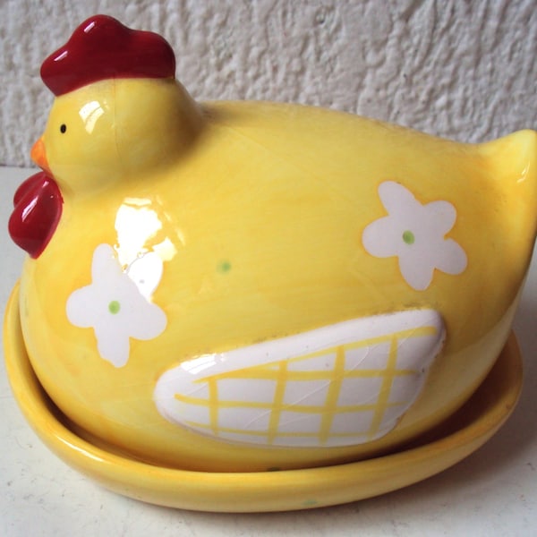 Beurrier en céramique de couleur jaune représentant une poule sur son nid et datant des années 1970.