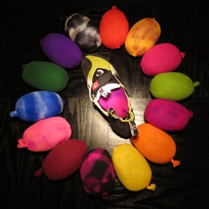 Peut inclure: Un assortiment coloré de balles recouvertes de tissu disposées en cercle autour d'une chaussure d'escalade noire. Les balles sont de différentes nuances de bleu, vert, rose, violet, rouge, jaune et orange.