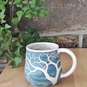 Op de draaischijf vervaardigde steengoedmok – Sgraffito boomvogels, verdigris gespikkelde crèmekleurige glazuur