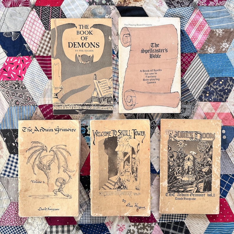 Puede incluir: Una colecci&oacute;n de libros de juegos de rol de fantas&iacute;a vintage. Los t&iacute;tulos incluyen "The Book of Demons", "The Spellcaster's Bible" y vol&uacute;menes de "The Arduin Grimoire". Los libros presentan ilustraciones y texto en un estilo cl&aacute;sico y envejecido, con varios dise&ntilde;os de portada.