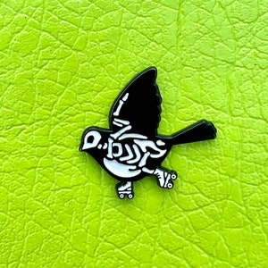 Roller skate skeleton bird glow in the dark 1” soft enamel pin