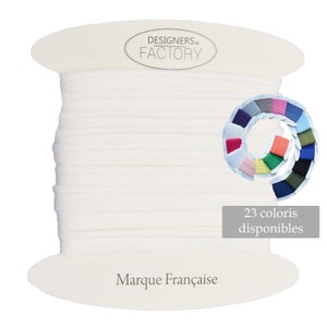 Könnte beinhalten: Eine Spule weißen Kordels mit dem Text "DESIGNERS FACTORY" und "Marque Française" auf dem Etikett. Eine Farbkarte zeigt 23 verfügbare Farben.
