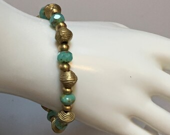 May include: A gold and turquoise beaded bracelet with alternating round and faceted beads.