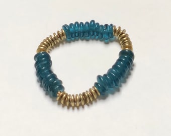 May include: A blue and gold beaded bracelet with a stretchy band. The bracelet is made of small, round beads that are strung together in a repeating pattern.