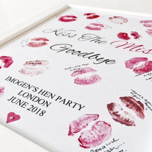 May include: White framed sign with the text "Kiss the Miss Goodbye" in black cursive script. The sign is decorated with red lipstick kisses and the text "Imogen's Hen Party, London, June 2018".
