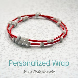 May include: A red and white beaded bracelet with the text "Personalized Wrap Morse Code Bracelet".