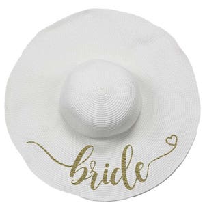May include: White sun hat with a gold glitter "bride" inscription and a small heart.