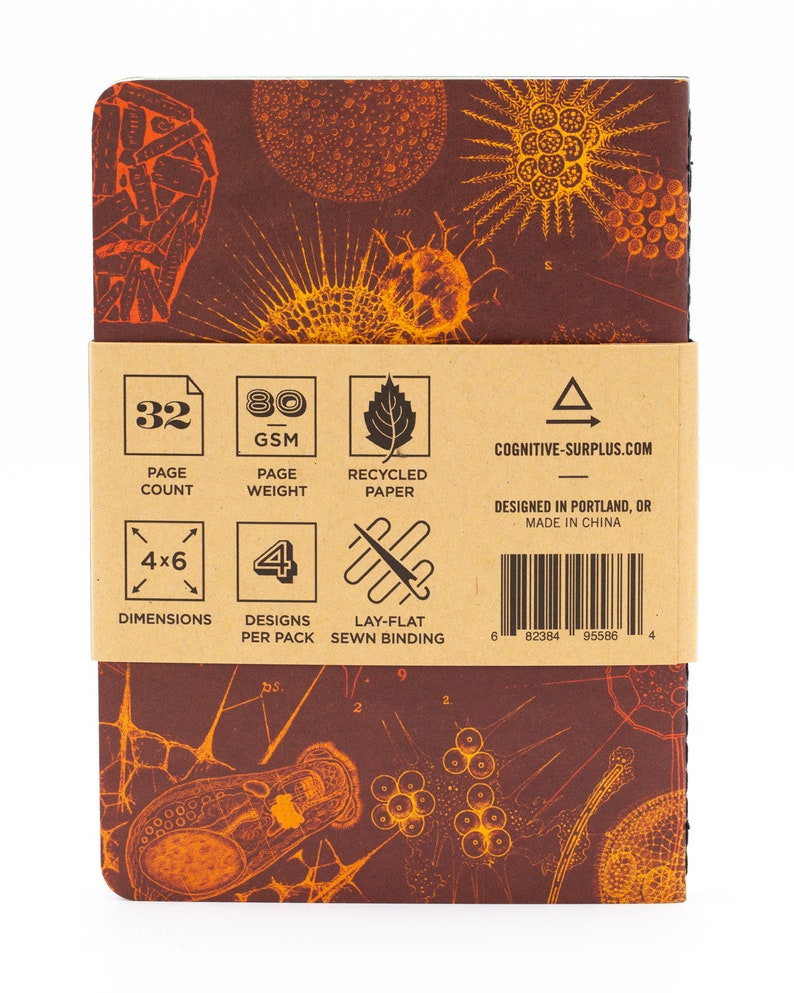 May include: A brown notebook with a vintage illustration of microscopic organisms on the cover. The back of the notebook has details about the paper, page count, and dimensions. The text on the back reads: 32 Page Count, 80 GSM Page Weight, Recycled Paper, 4x6 Dimensions, 4 Designs Per Pack, Lay-Flat Sewn Binding, Cognitive-Surplus.com, Designed in Portland, OR, Made in China.