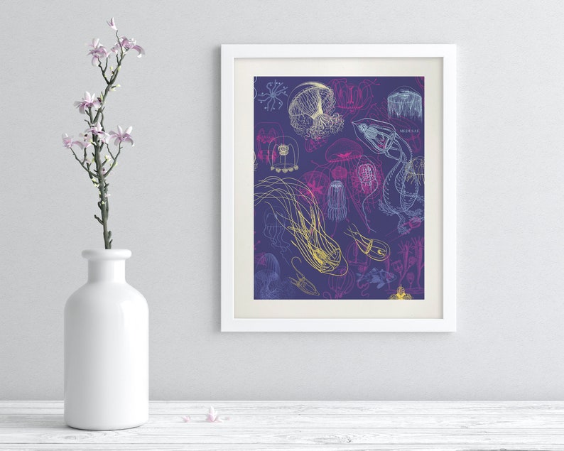 May include: A framed art print featuring a detailed illustration of various jellyfish in shades of yellow, blue, and pink on a dark purple background. The artwork is displayed in a white frame and is part of a home decor collection.
