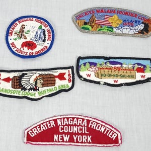 May include: A collection of embroidered patches featuring various designs and text. The patches include the words "Greater Niagara Frontier Council," "Boy Scouts of America," and "Ganosote Lodge Buffalo Area." The patches are in various shapes and colors.