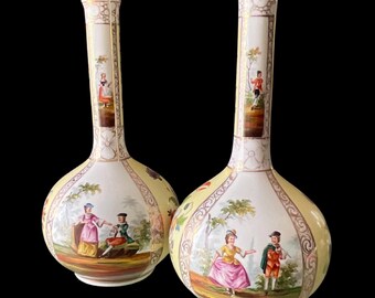 May include: A pair of antique porcelain vases with a yellow background and intricate floral designs. Each vase features a painted scene of a couple in a garden setting.