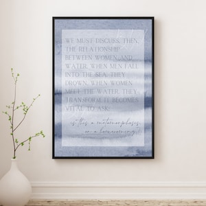Puede incluir: Impresión artística enmarcada con un fondo de acuarela azul. La impresión presenta un texto elegante que dice: "Debemos discutir, entonces, la relación entre las mujeres y el agua... ¿Es esto una metamorfosis o un regreso a casa?"
