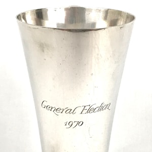 May include: A silver cup with a round base and a flared top. The cup is engraved with the text "General Election 1970".