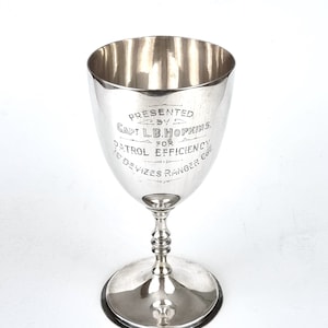 Puede incluir: Trofeo de copa de plata con una inscripción que dice "Presented by Capt. L.B. Hopkins for Patrol Efficiency Devizes Ranger Co."