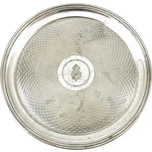 May include: A silver serving tray with a raised rim and a decorative, woven pattern on the surface. The center of the tray has a small, circular design.