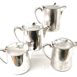 May include: Set of four silver teapots with lids. The teapots are all the same size and shape, and they have a classic design.