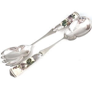 May include: A set of silver salad servers with porcelain handles decorated with floral designs in shades of pink, green, and white.