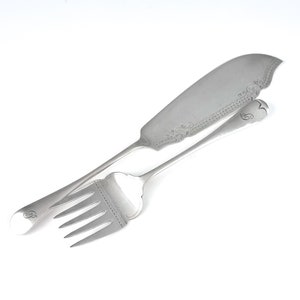 May include: A silver butter knife and fork set with an ornate design and a letter 'B' engraved on the handles.